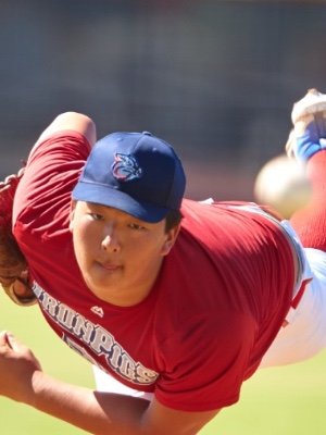 Asian Pitcher Throwing a Baseball